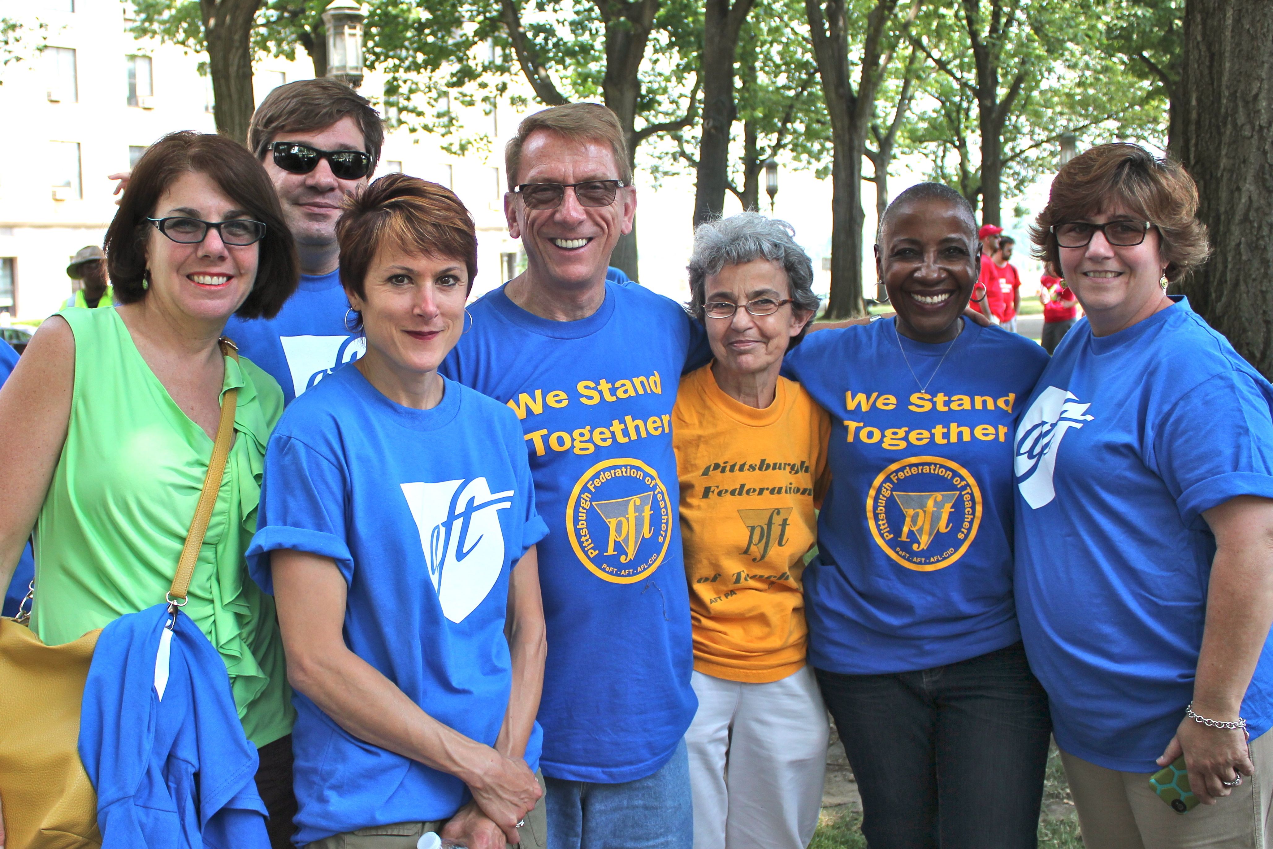 A group of seven people in brightly colored t-shirts.
